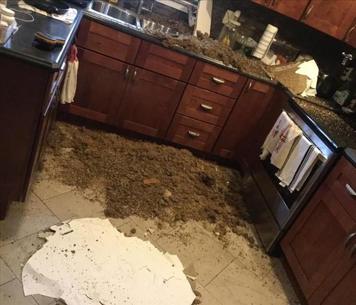 Kitchen with ceiling debris all over counter and floor